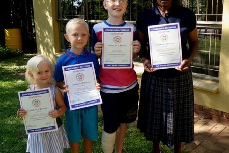 Callie Lotz se kleinkinders met hul sertifikate vir braafheid, met vlnr Juliette, Vince en Leo Lotz, saam met Veronica Hlopulusa wat ook ‘n sertifikaat ontvang het 